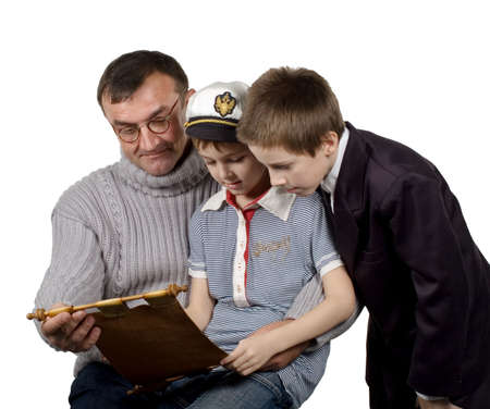 The man shows a map and tells to boys about the far countries and travelの写真素材