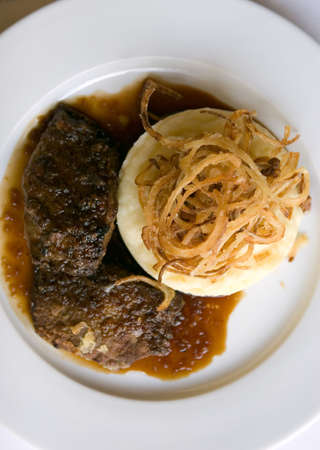 The veal liver with  mashed potaotes and crackling onions on plate.の写真素材