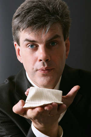 Portrait of a man blowing a kiss. Isolated against gray backgroundの写真素材