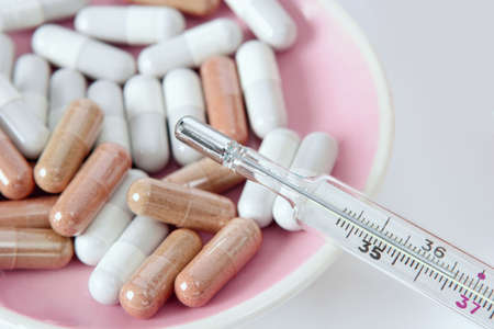 Medical thermometer and different types of vitamins pills. The health concept.の写真素材