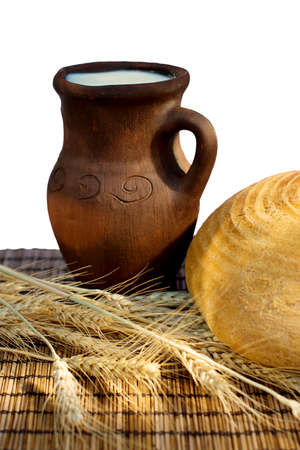 Bread ,wheat ears and jug with milk on a bamboo mat. の写真素材