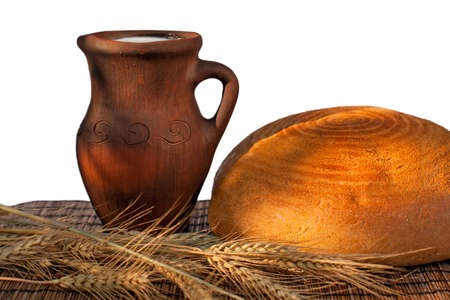 Bread ,wheat ears and jug with milk on a bamboo mat.の写真素材