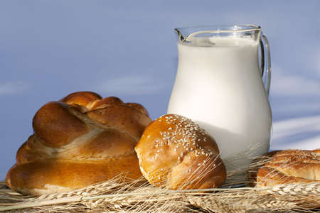 Baking bread, wheat ears and jug with milk on a bamboo mat. の写真素材