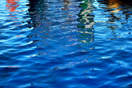 Rhythmical water pattern with multi-colored waves and solar patches of light