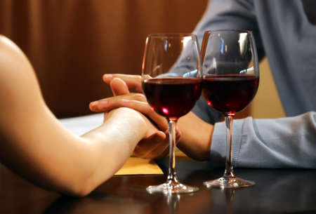 Concept of love of man and woman. Two coupled hands  and two wineglassesの写真素材