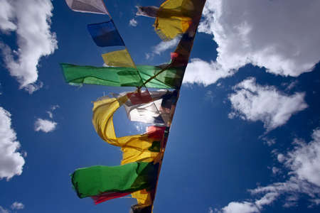 Praying flags floating in the wind on blue sky 