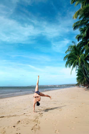 A  young  women doing cartwheels on the beachの写真素材