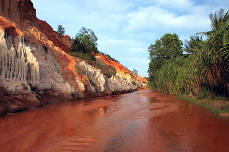 Red river between rocks and jungle. Ham Tien canyon. Mui ne, Vietnamの写真素材