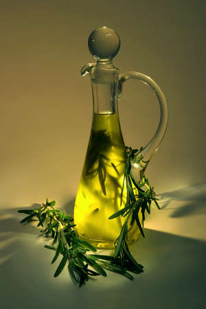 Olive oil with rosemary in a glass jug, on dark backgroundの写真素材