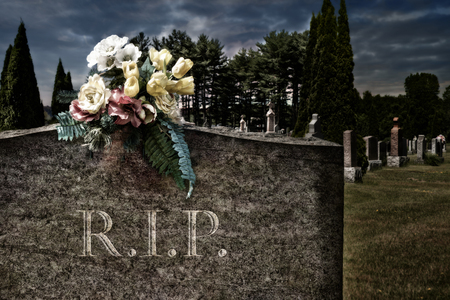 Flowers on a headstones in a cemetery, bokeh effect in background.の写真素材