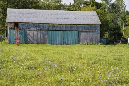 Old barn on a farm, sunny summer day.の写真素材