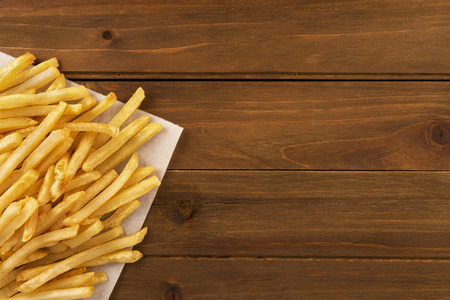 French fries with ketchup on wooden background, directly above. Close up.の写真素材