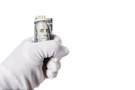 Banknote one hundred dollars, sandwiched in hand as a symbol of financial crisisの写真素材