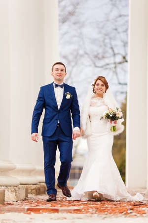 Bride and bridegroom on the background of columnsの写真素材