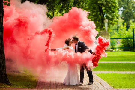 The bride and groom with a red smoke on background summer natureの写真素材