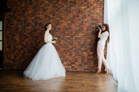 Young sexy photographer is taking pictures the model in the studioの写真素材