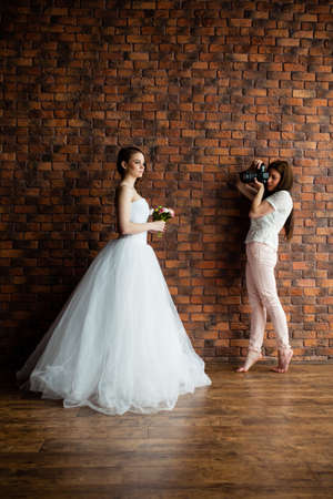Young sexy photographer is taking pictures the model in the studioの写真素材