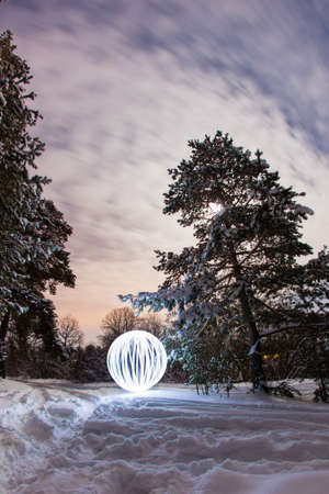 Luminous sphere in a night winter forest and the light of the full moonの写真素材