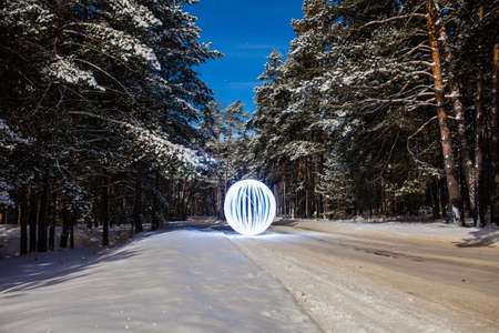 Futuristic glowing sphere on a background of a beautiful winter landscape in full moonの写真素材