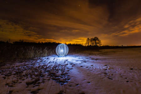 Luminous sphere on a frozen lake and the light of the full moonの写真素材