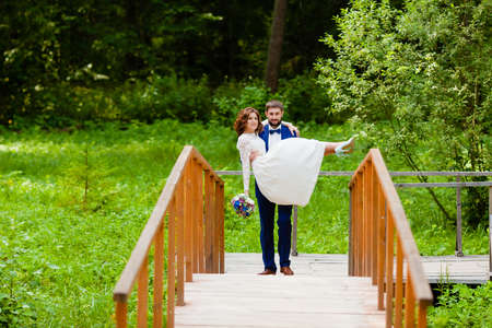 Bride and groom walking on a wooden bridgeの写真素材