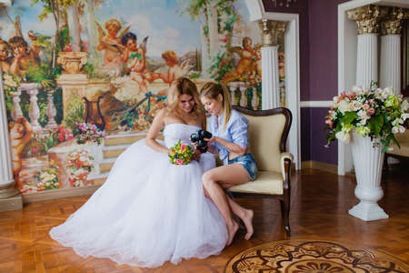 Wedding photographer discussing with the bride recently taken photosの写真素材