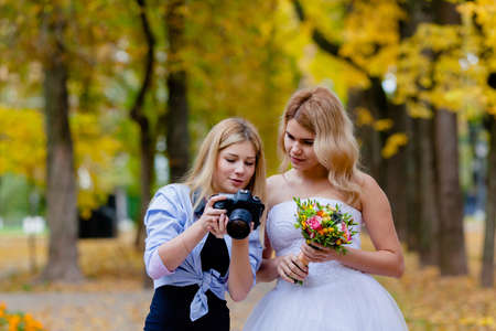 Wedding photographer discussing with the bride recently taken photosの写真素材