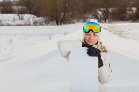 Portrait of young woman with her snowboardの写真素材