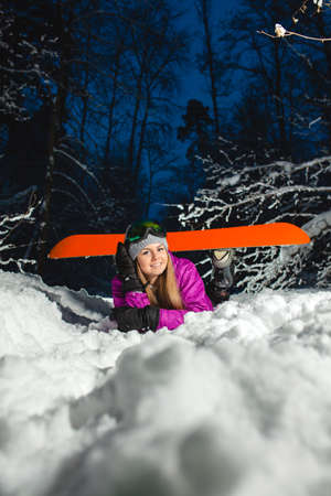 Portrait of the young sexy snowboarder in the dark winter forestの写真素材