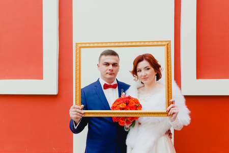Groom and bride with the golden frameの写真素材