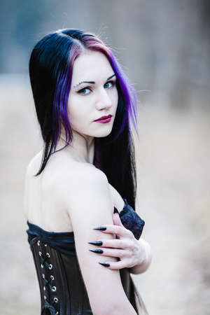 Close-up portrait of the gothic woman in the dark winter forestの写真素材