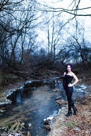 Portrait of the gothic woman near the cold creek