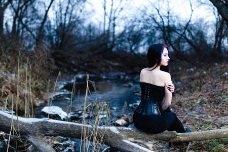 Portrait of the gothic woman near the cold creek