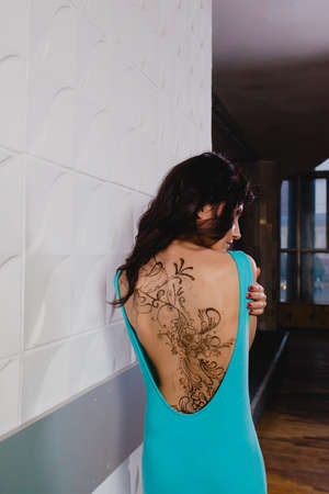 Slender brunette with henna ornaments drawn on her backの写真素材
