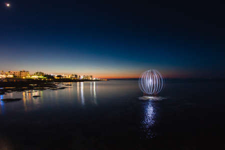 Futuristic glowing sphere and the seaの写真素材