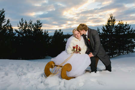 Bride and groom with big wooden sledの写真素材
