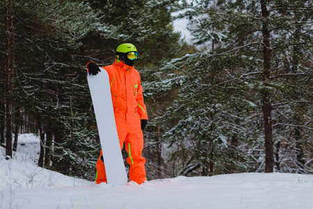 Snowboarder posing in winter forestの写真素材