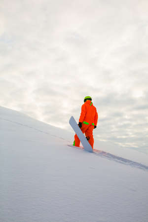 Snowboarder climbing on the top of ski slopeの写真素材