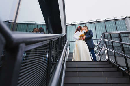 Beautiful couple newlyweds on a metal staircaseの写真素材