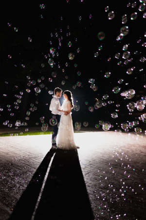 Couple of newlyweds in the darkness at the background of flash of lightの写真素材