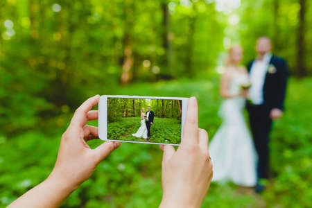 Somebody is using smartphone to make a photo of newlywedsの写真素材