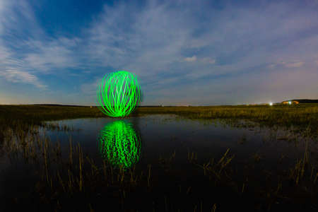 Futuristic glowing sphere reflected on the river surface