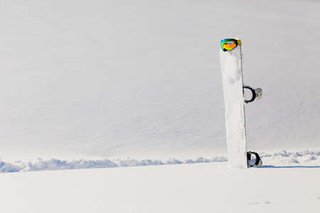 Snowboard and ski laying on a snow near the free ride slopeの写真素材