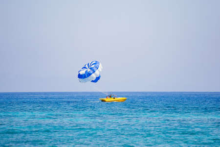 Couple of tourists flies on a blue and white parachuteの写真素材