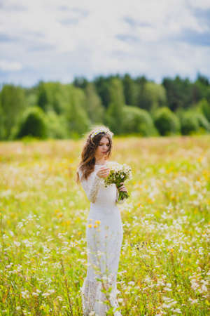 Close-up portrait of a beautiful bride with chamomilesの写真素材