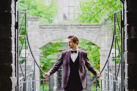 Handsome young bridegroom posing on the territory of country hotelの写真素材