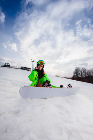 Young beautiful woman posing with a snowboard on a ski slopeの写真素材