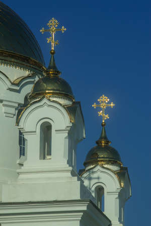 gilded domes of an Orthodox church with crosses against a blue skyの写真素材
