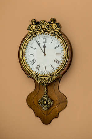 Christmas and New Year clock on brown wall. 5 minutes before the holiday (2). Idea for holiday like Christmas and New year, for covers books, magazines, articles.の写真素材