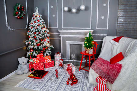 Christmas and New Year photo studio, tree, box, presents, garlands, gray wall, balls, pillow, sofa, fireplace (1). Idea for holiday like Christmas and New year, for covers books, magazines, articles.の写真素材